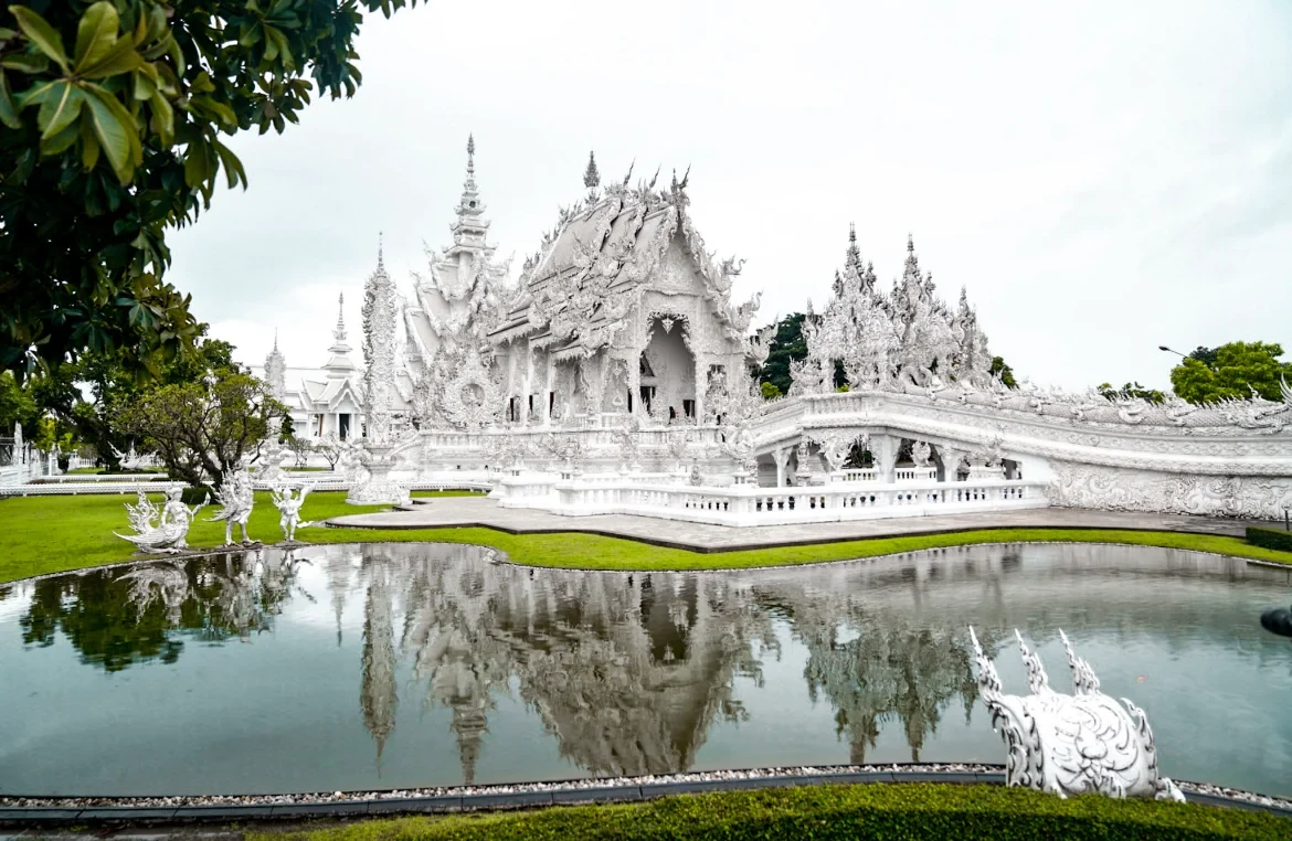 El Templo Blanco, Wat Rong Khun, reflejado en el estanque que lo rodea en Chiang Rai