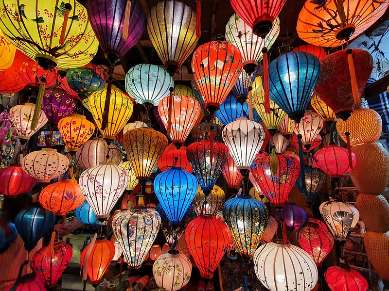 Farolillos de seda de colores encendidos en un taller de Hoi An
